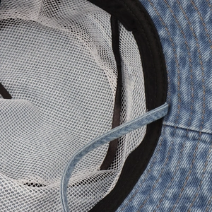 Detail of denim bucket hat showing breathable mesh lining and adjustable chin cord