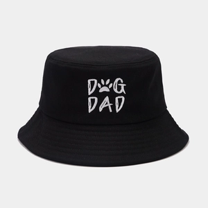 Dettaglio del ricamo bianco DOG DAD con zampetta su un cappello a secchiello nero in cotone