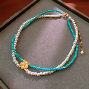 Detail of a vintage double-layer necklace with white pearls and turquoise beads