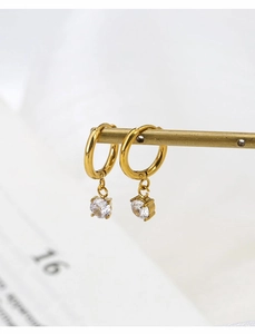 Detail of gold-plated stainless steel hoop earrings with white zircon on a brass rod