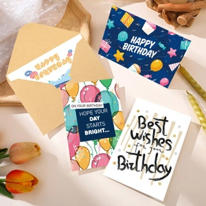 Flat lay of colorful birthday cards and envelopes with warm ambient decor and dried flowers