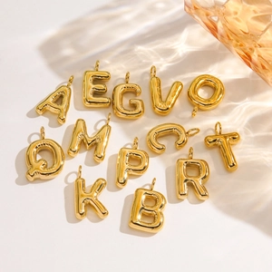 Polished 14K gold 3D balloon-style alphabet pendants in stainless steel on light background