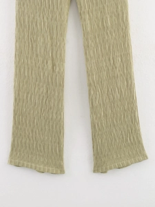 Détail du pantalon vert olive en tissu plissé avec finitions de couture de qualité