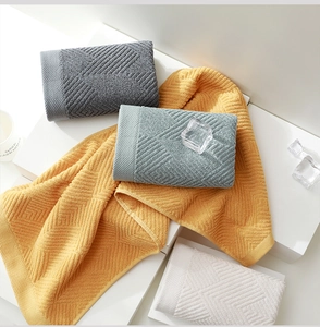 Détail de la texture gaufrée géométrique sur les serviettes en coton doux et épais