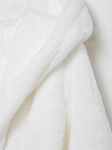 Close-up of premium white faux fur coat showing soft plush texture and fluffy fibers