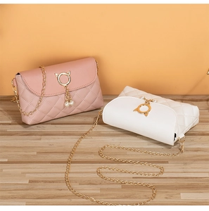 Detail of pink and white quilted mini crossbody bags with gold cat ear clasps and pearls
