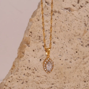 Macro detail of gold marquise eye pendant with zircon stone on Singapore twist chain
