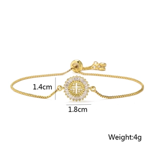 Macro shot of gold adjustable bracelet with crystal pavé cross pendant and size specs