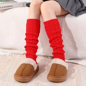 Close-up of red cable knit leg warmers showing thick texture and stylish slouchy fit