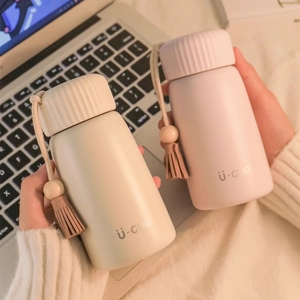 Mini insulated vacuum flasks in cream and pink colors with wrist straps for daily use