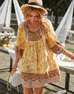 Détail d'une robe jaune à fleurs vintage avec col en V dans un décor de jardin extérieur