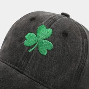 Close-up of vintage washed grey cotton baseball cap with green shamrock clover embroidery
