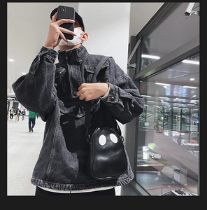 Close-up of a black PU leather crossbody bag featuring white cartoon eye ghost pattern