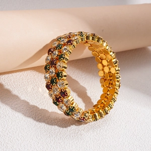 Detailed view of triple-layered gold bracelet with colorful rhinestones on a roll