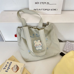 Detail of light green tote bag with cute 3D bunny embroidery and pleated drawstring top