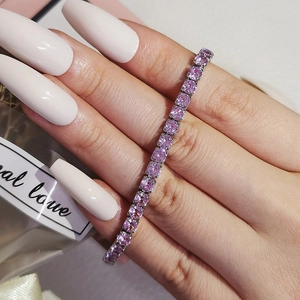 Close-up of pink zircon tennis bracelet with four-claw setting on a silver-tone chain