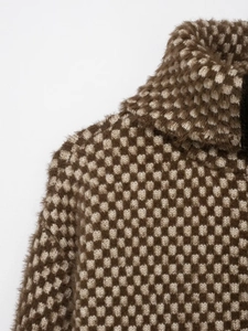 Close-up of high neck chunky knit sweater featuring brown heart pattern and soft texture