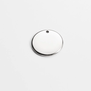 Macro view of a blank silver stainless steel round pendant with a small hole and smooth finish