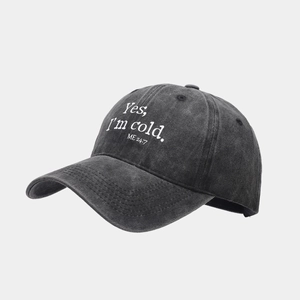 Detail of washed black cotton baseball cap with white slogan text Yes I am cold ME 24 7