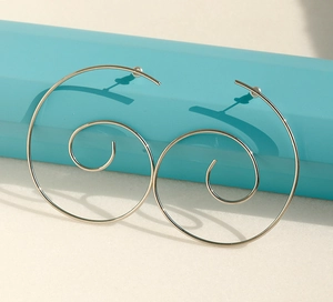 Macro detail of silver spiral hoop earrings with elegant double loop design