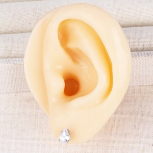 Detailed close-up of water drop zircon silver stud earrings on a realistic ear model