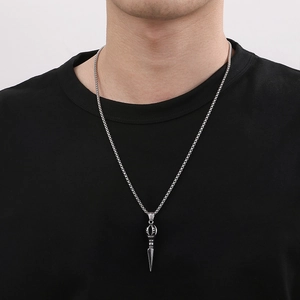 Macro view of a stainless steel Vajra pestle pendant with a woven texture chain on black shirt