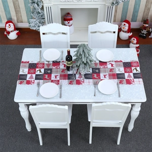 Close-up of Christmas table runner with reindeer and snowflake prints on plaid fabric
