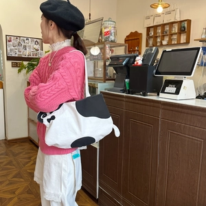 Detail of cute cat canvas tote bag with black and white cow print and tail decoration