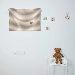 Detail of khaki plaid fabric car curtain featuring a cute embroidered teddy bear design