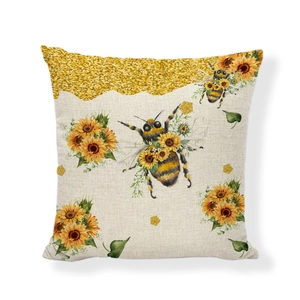 Detail of linen cushion cover featuring printed honeybees and sunflowers on a beige fabric