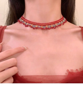 Vue rapprochée d'un collier ras de cou rouge fait main avec perles en cristal et doré