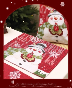 Detailed view of red Christmas placemat and pillow featuring jacquard snowman patterns