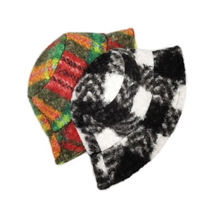 Detailed view of thick plaid bucket hats in colorful and black-white checkered fleece