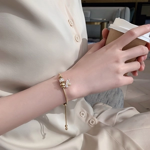 Close-up of golden snake chain bracelet with zircon charms on a woman's wrist
