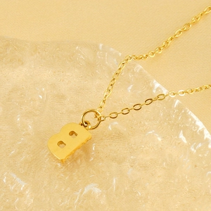 Vue macro d'un collier en acier doré avec pendentif lettre B orné de cristaux brillants