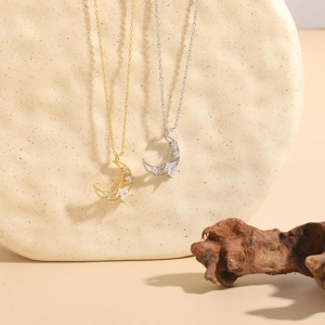 Macro shot of gold and silver moon and star necklaces with zircon on textured rock