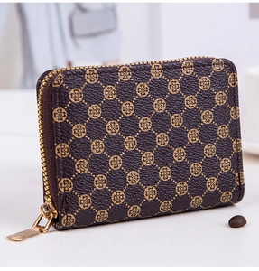 Detail view of mini wallet in brown synthetic leather with gold clover pattern and zipper