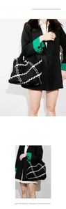 Detailed close-up of the black and white woven tote bag with artistic geometric patterns