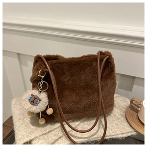 Detail of dark brown plush shoulder bag with leather strap and alpaca charm ornament