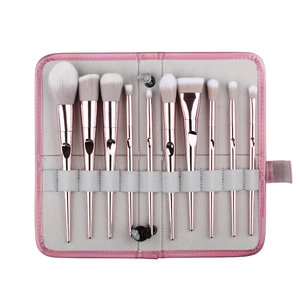 10-piece makeup brush set with rose gold handles in a pink laser holographic roll bag