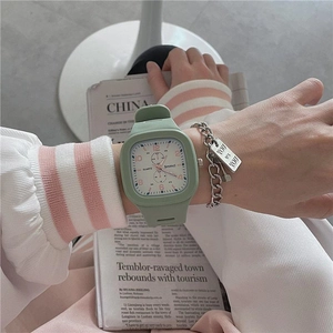 Detail of light green square sports watch with silicone strap on wrist with jewelry