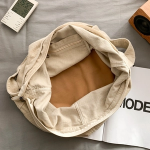 Minimalist beige corduroy tote bag with zipper closure and brown inner lining pockets