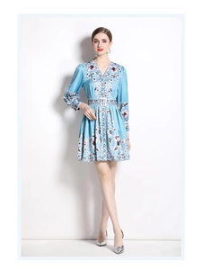 Detail of vintage V-neck floral dress showing light blue silk texture and waist belt
