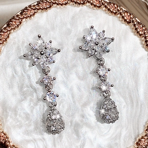 Dettaglio degli orecchini da sposa in argento con zirconi a forma di fiore e goccia