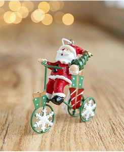 Close-up of Santa Claus on a red tricycle ornament with snowflake wheels on wood background