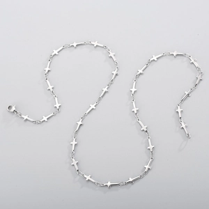 Minimalist silver stainless steel necklace featuring unique handmade cross links on grey background