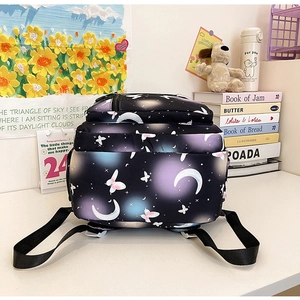 Black school backpack with star, moon and butterfly prints in a cozy student study setup