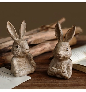 Detailed view of two vintage-style rabbit statues with realistic faux wood texture