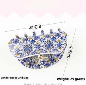 Detail view showing 8.3cm floral hair claw clip with Mediterranean blue and yellow pattern