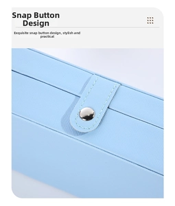 Detail of light blue Saffiano leather jewelry box featuring a silver metal snap button